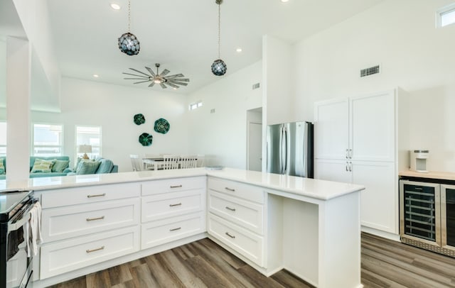 kitchen featuring decorative light fixtures, dark hardwood / wood-style flooring, beverage cooler, appliances with stainless steel finishes, and white cabinetry