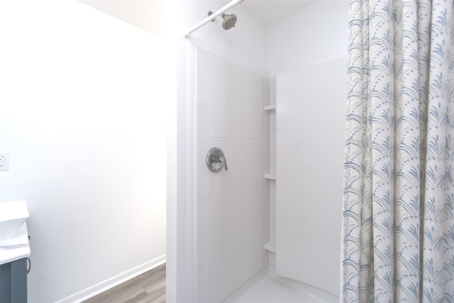 bathroom featuring a shower with shower curtain, hardwood / wood-style floors, and vanity