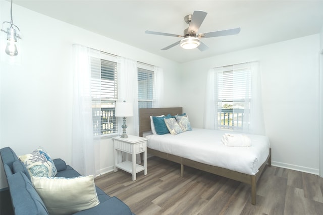 bedroom featuring multiple windows, ceiling fan, and dark hardwood / wood-style floors