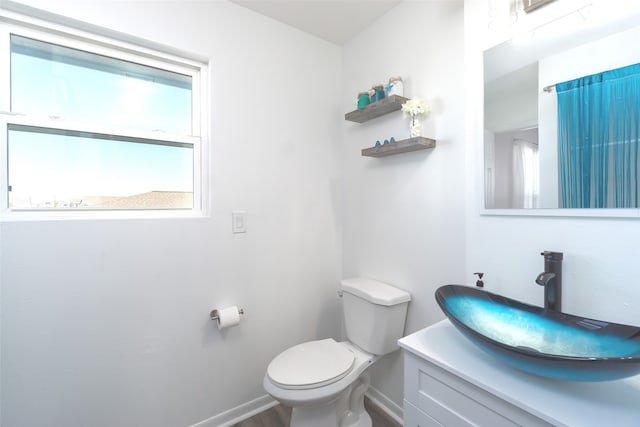 bathroom with vanity, toilet, and wood-type flooring