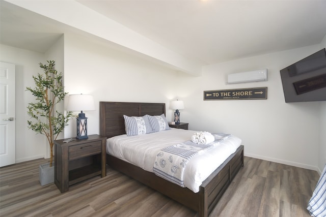 bedroom with dark wood-type flooring and a wall mounted air conditioner