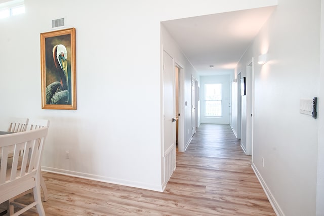 hallway with light hardwood / wood-style floors