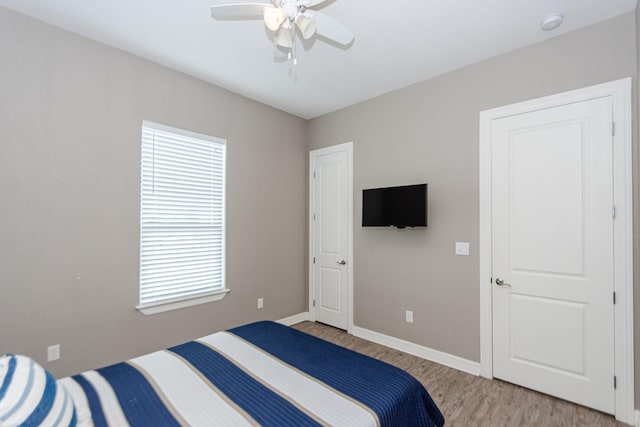 bedroom featuring multiple windows, ceiling fan, and light hardwood / wood-style floors