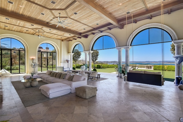 interior space featuring beam ceiling, ceiling fan, wood ceiling, and ornate columns