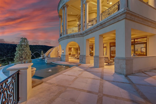 pool at dusk featuring a patio area