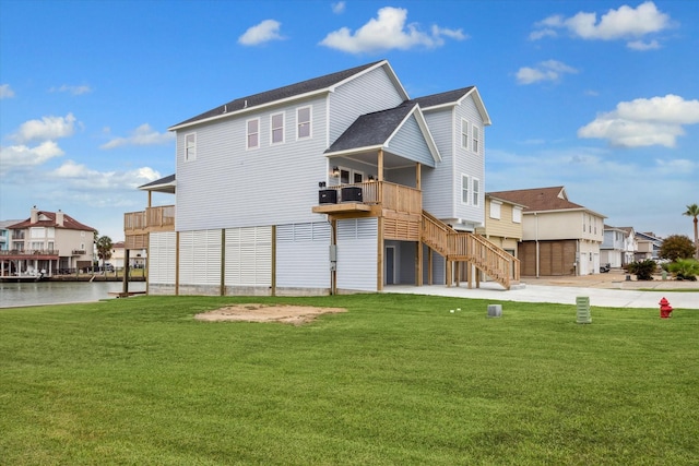 rear view of property with a lawn and a water view