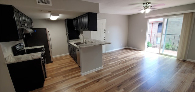 kitchen with light stone countertops, ventilation hood, and light hardwood / wood-style flooring