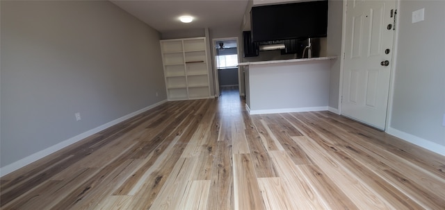 unfurnished living room featuring light wood finished floors and baseboards