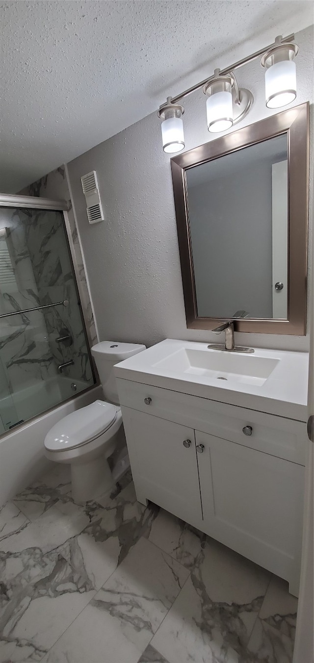 full bathroom with vanity, a textured ceiling, toilet, and shower / bath combination with glass door