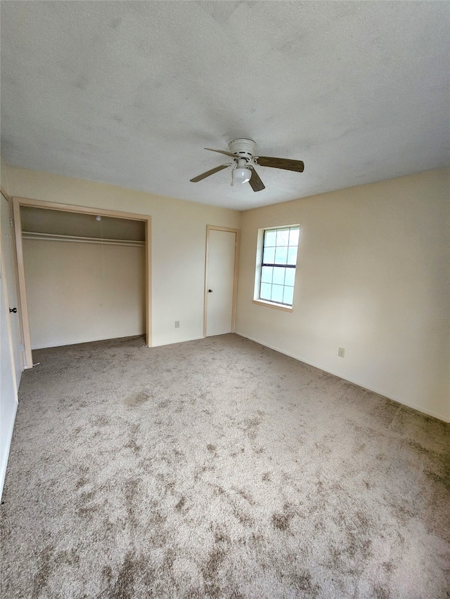 spare room with a textured ceiling, carpet, and ceiling fan