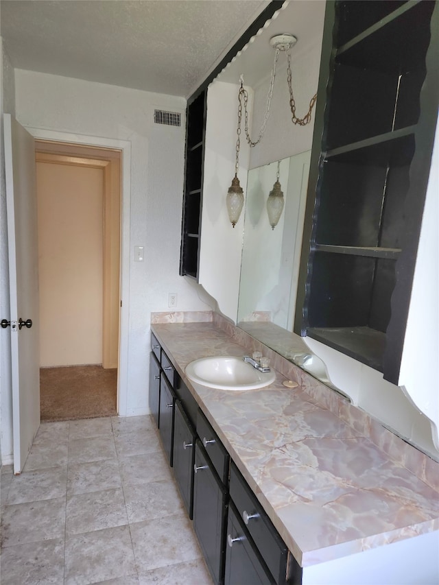 bathroom with a textured ceiling, tile flooring, and oversized vanity