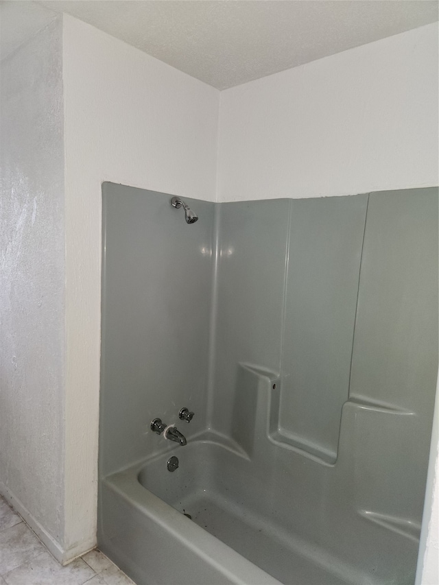 bathroom featuring washtub / shower combination and tile flooring