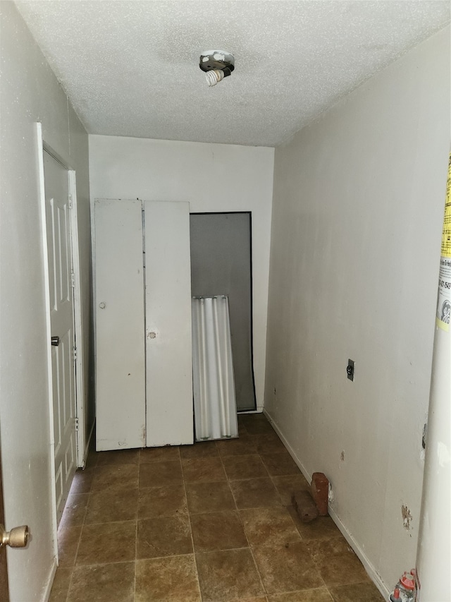 unfurnished bedroom featuring dark tile floors and a textured ceiling