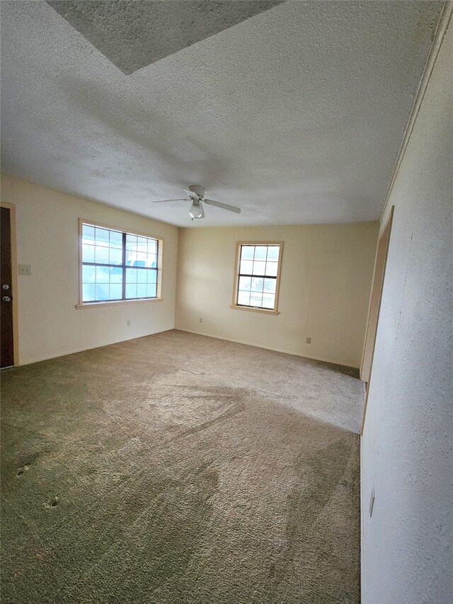 spare room featuring carpet floors, a textured ceiling, and ceiling fan