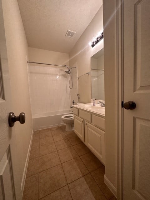 full bathroom with vanity, tiled shower / bath, tile flooring, a textured ceiling, and toilet