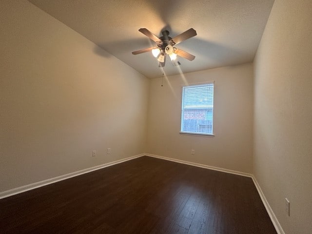 spare room with lofted ceiling, dark hardwood / wood-style floors, and ceiling fan