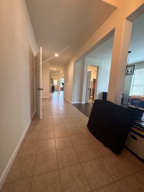 corridor featuring plenty of natural light and light tile flooring