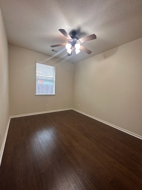 spare room featuring ceiling fan, a textured ceiling, and dark hardwood / wood-style flooring