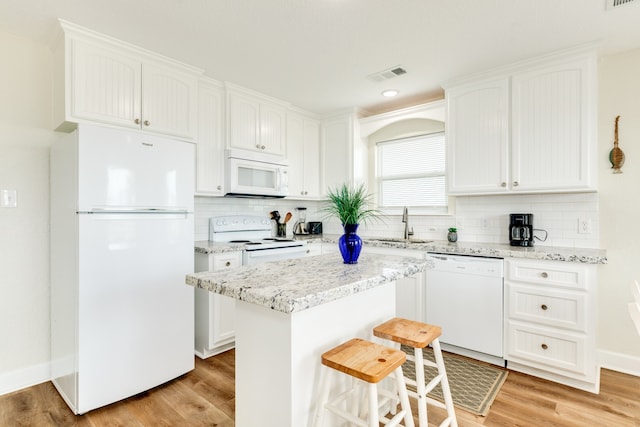 kitchen featuring tasteful backsplash, light hardwood / wood-style floors, white appliances, and white cabinetry