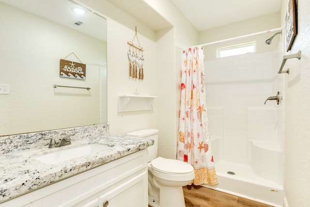 bathroom with hardwood / wood-style floors, toilet, vanity, and a shower with shower curtain