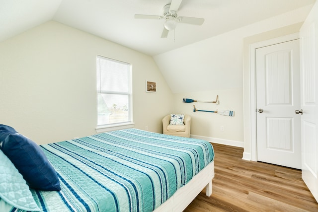 bedroom featuring a closet, lofted ceiling, ceiling fan, and light wood-type flooring