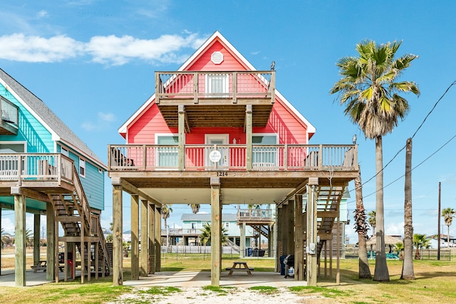 back of property featuring a balcony and a wooden deck