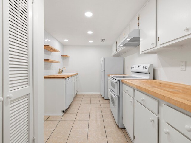 kitchen featuring white cabinets, white appliances, and butcher block countertops