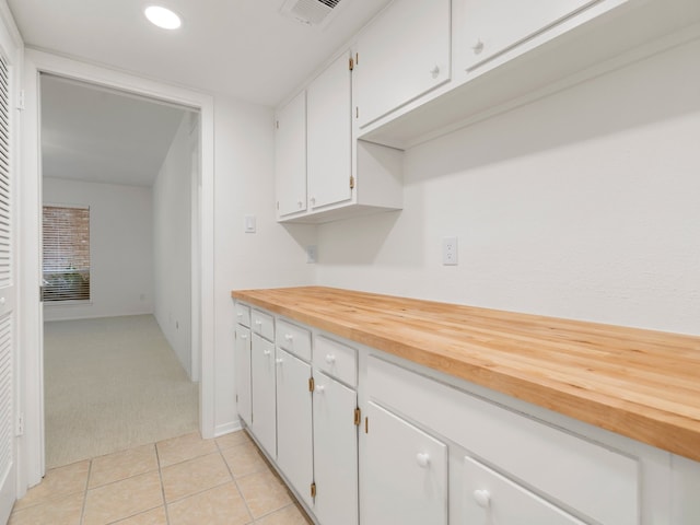 kitchen featuring white cabinets and light tile floors