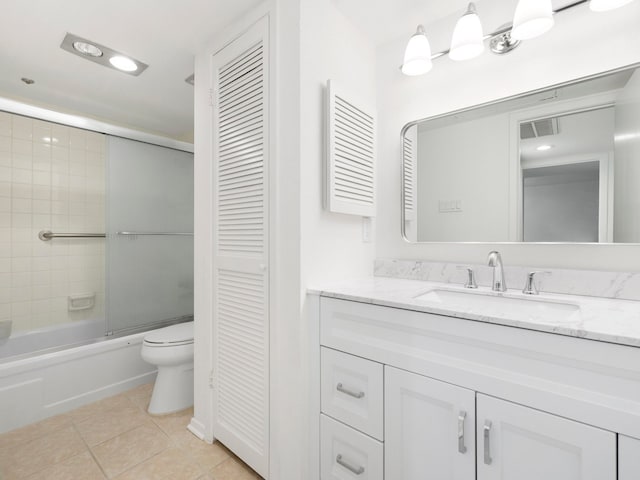 full bathroom featuring bath / shower combo with glass door, toilet, oversized vanity, and tile floors