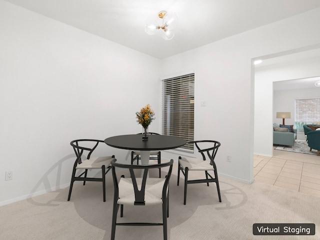 carpeted dining space with a chandelier