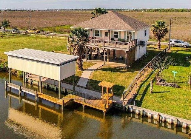 exterior space featuring a water view, a rural view, and a lawn