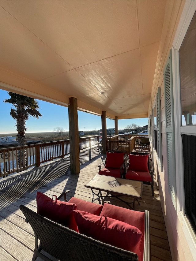 wooden deck featuring a water view and an outdoor hangout area