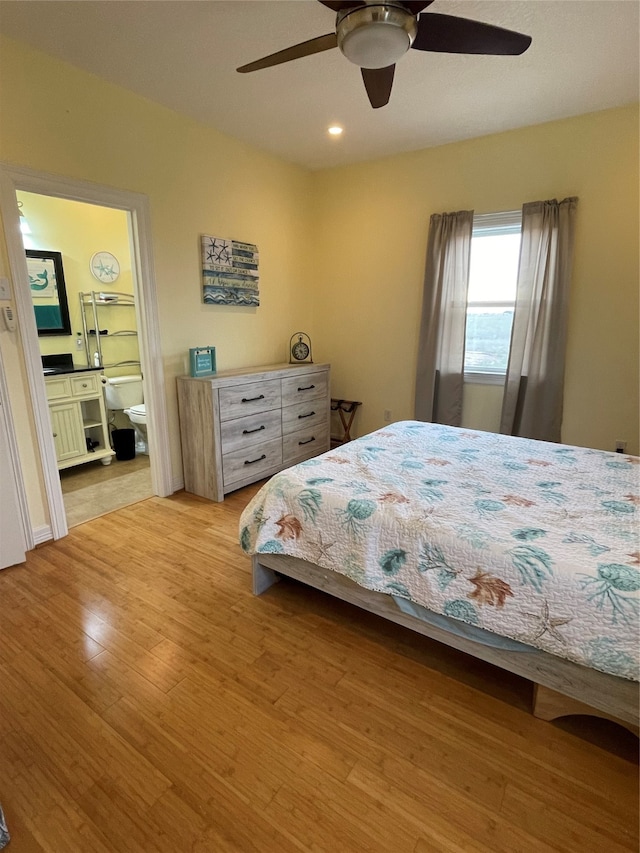 bedroom with ensuite bath, light hardwood / wood-style floors, and ceiling fan