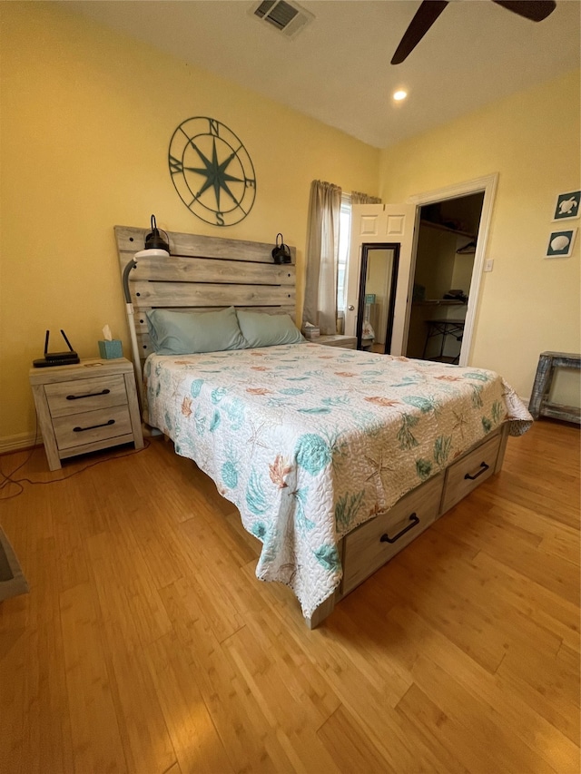 bedroom featuring ceiling fan, a spacious closet, and light wood-type flooring