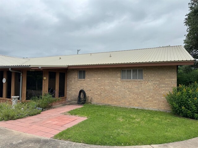 713 Sarah Jo St, La Grange, TX 78945 - back of house with a yard, metal roof, and brick siding