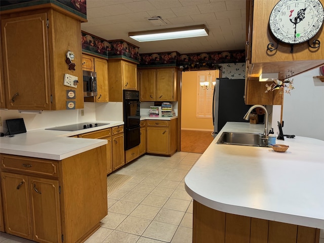 kitchen with sink, kitchen peninsula, black appliances, and light tile patterned floors