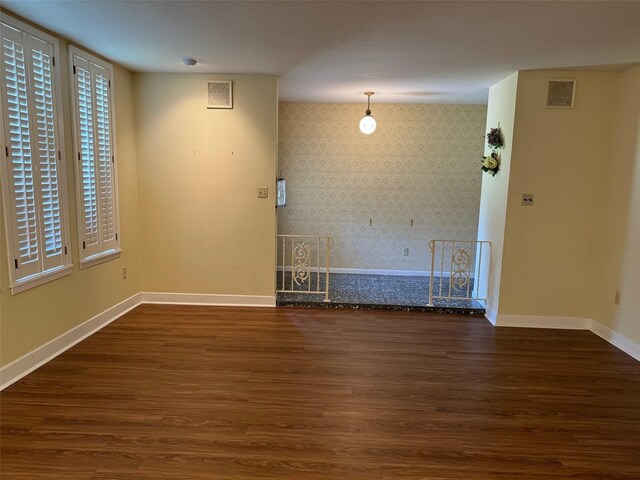713 Sarah Jo St, La Grange, TX 78945 - spare room featuring wallpapered walls, baseboards, wood finished floors, and an accent wall