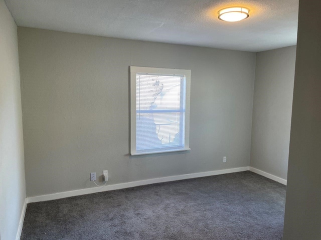 carpeted spare room featuring a textured ceiling