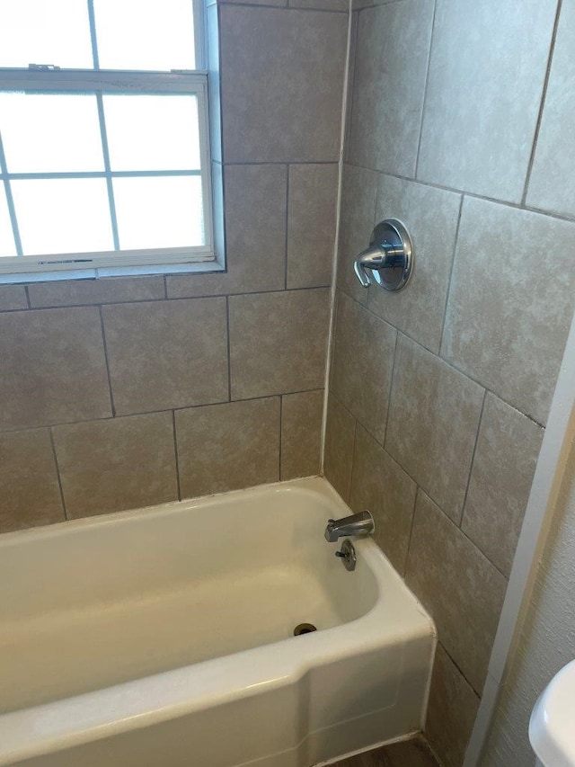 bathroom featuring tiled shower / bath