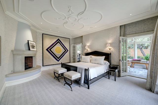 bedroom with french doors, ornamental molding, light carpet, and a large fireplace