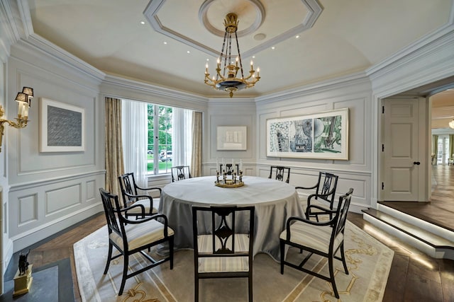 dining room featuring light parquet floors, ornamental molding, a chandelier, and a tray ceiling