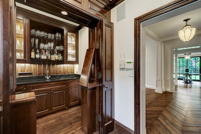 bar featuring dark brown cabinets, crown molding, dark parquet flooring, wooden counters, and sink