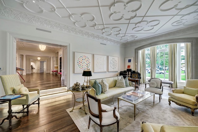 living room featuring hardwood / wood-style floors, crown molding, and coffered ceiling