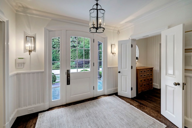 entryway with dark hardwood / wood-style flooring, a notable chandelier, and ornamental molding