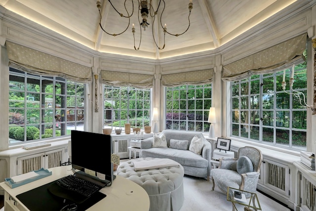 sunroom featuring a tray ceiling and a notable chandelier