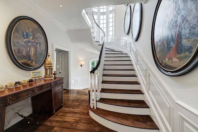 stairway with ornamental molding and dark hardwood / wood-style flooring