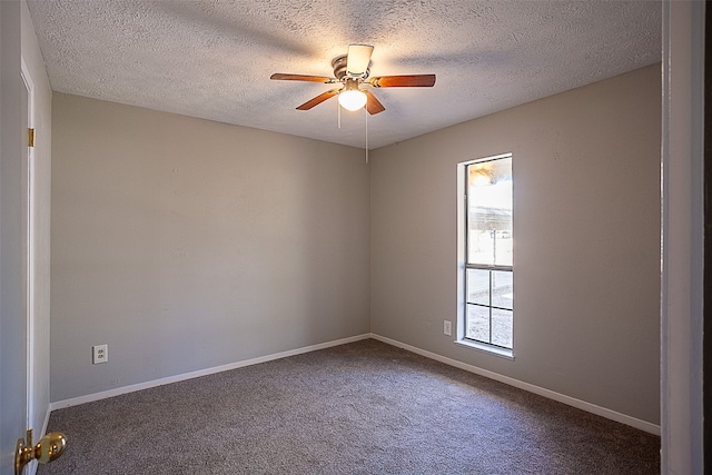 unfurnished room with ceiling fan, dark carpet, and a textured ceiling