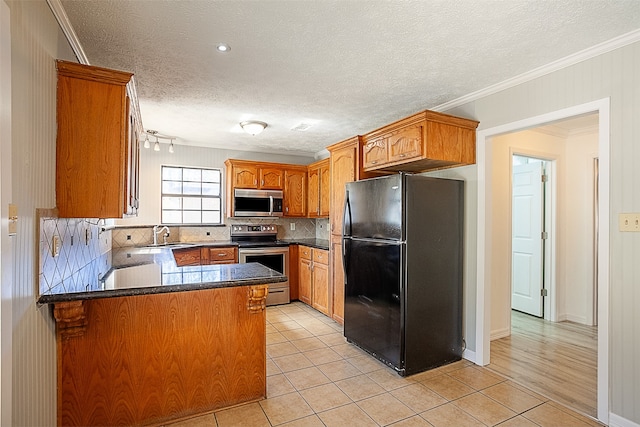 kitchen with stainless steel appliances, a textured ceiling, tasteful backsplash, ornamental molding, and light wood-type flooring