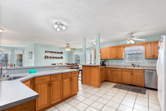 kitchen with dishwasher, a textured ceiling, light tile patterned flooring, and sink