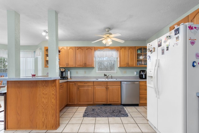 kitchen with white refrigerator with ice dispenser, sink, stainless steel dishwasher, ceiling fan, and kitchen peninsula